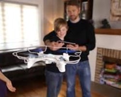 dad and son flying drone indoors